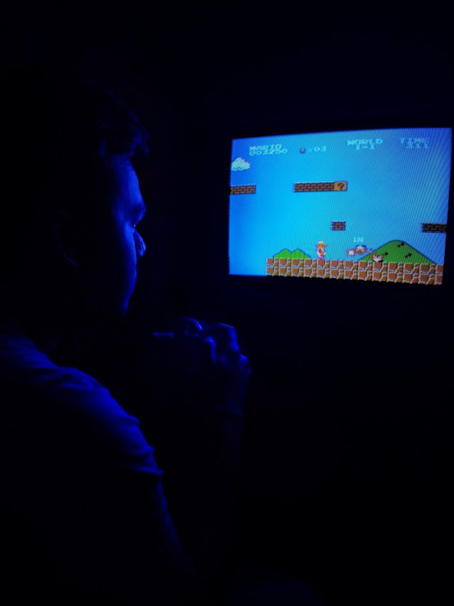 un uomo davanti a un vecchio televisore gioca a super mario bros.